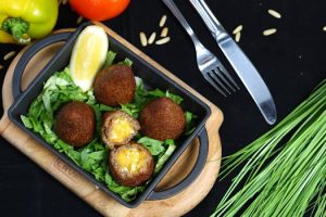 Delicious falafel served on a bed of fresh greens with lemon and vegetables.